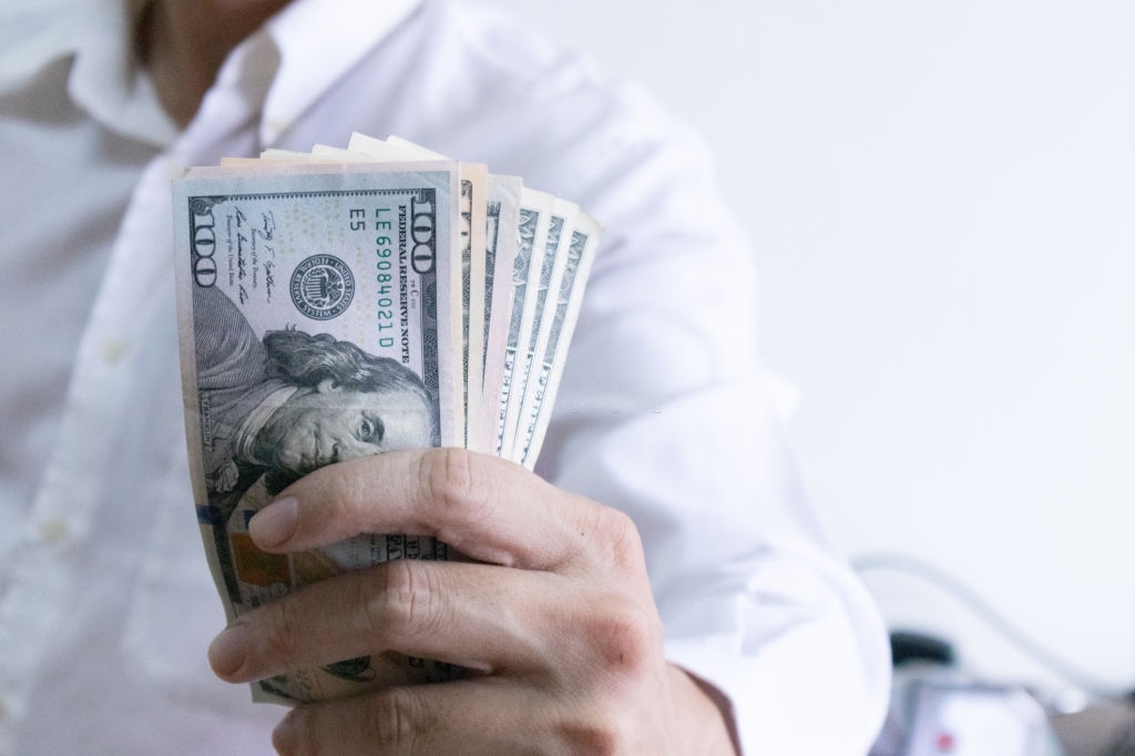 Man holding dollar banknote.young businessman holding money.Business and finances making and saving money concept.